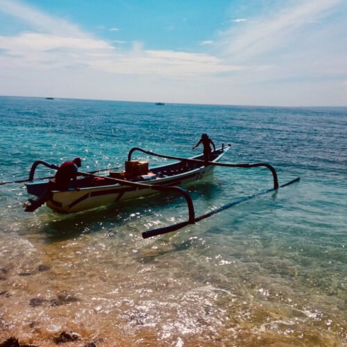 pêcheurs sur leur bateau à bali, sur la mer bleu azur